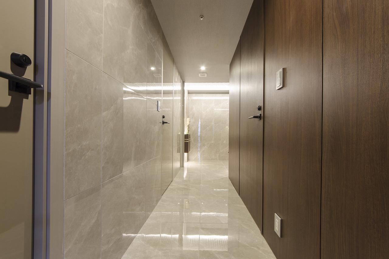 床はタイル貼り、壁はタイルと木パネルを貼った高級感ある廊下です
